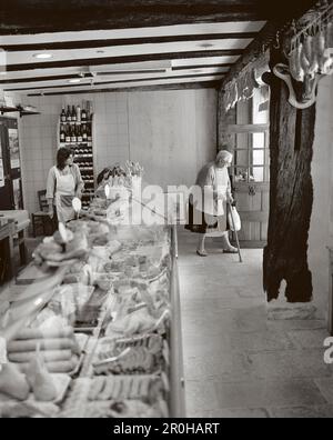 Francia, Borgogna, senior Donna che cammina con la canna da zucchero in Charcutier, Noyers (B&W) Foto Stock