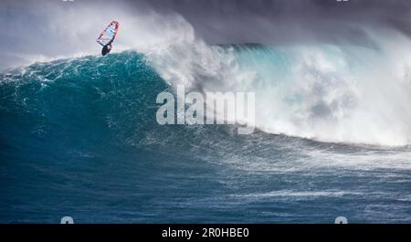 USA, Hawaii, Maui, un uomo windsurfs e prende l'aria su un'onda enorme in una pausa chiamata Jaws o Peahi Foto Stock