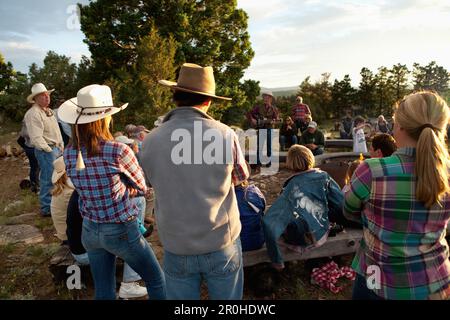 Stati Uniti d'America, Wyoming Encampment, gli ospiti di un dude ranch sedersi intorno a un falò e ascoltare un uomo suonare la chitarra e cantare canzoni country western, Abara Ranch Foto Stock