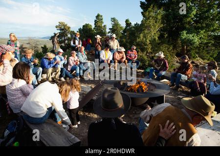 Stati Uniti d'America, Wyoming Encampment, gli ospiti di un dude ranch sedersi intorno a un falò e ascoltare un uomo suonare la chitarra e cantare canzoni country western, Abara Ranch Foto Stock