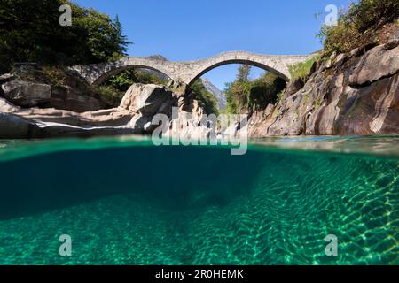 Vista sotto la superficie d'acqua del fiume Verzasca vicino a Lavertezzo con lo storico ponte dei sali nelle Alpi Svizzere, Canton ti Foto Stock