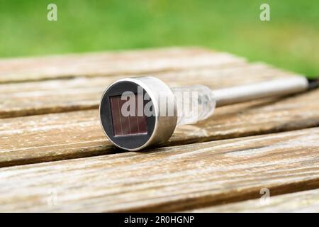 Lanterna da giardino a energia solare su un tavolo di legno. Energia ecologica, arredamento giardino. Foto Stock