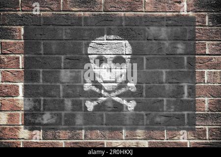Jolly Roger scull pirata e crossbones bandiera su vecchio muro di mattoni sfondo Foto Stock