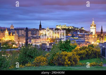 Vista della città di Edimburgo, illuminata di notte, con la St Giles' Cathedral, il castello di Edimburgo e il Balmoral Hotel, Calton Hill, patrimonio dell'umanità dell'UNESCO si Foto Stock