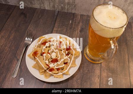 zuppa di gnocchi di formaggio austriaco su legno con birra Foto Stock