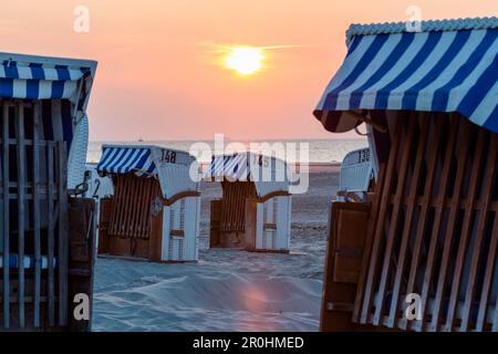 Sedie a sdraio sulla spiaggia al tramonto, Spiekeroog Island, nel Mare del Nord est delle Isole Frisone, Frisia orientale, Bassa Sassonia, Germania, Europa Foto Stock