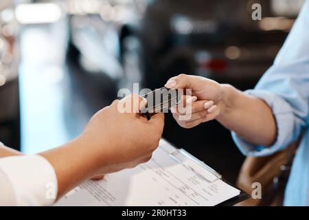 Il suo tempo per voi di guidare verso il tramonto. un venditore di auto che consegna le chiavi a un cliente. Foto Stock