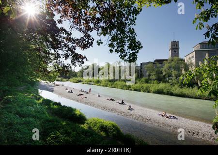 Persone che prendono il sole sul fiume Isar, Deutsches Museum in background, Monaco, Baviera, Germania Foto Stock