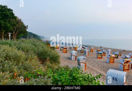 Sedie a sdraio con cappuccio sulla spiaggia al tramonto, Mar Baltico, Timmendorfer Strand, Schleswig-Holstein, Germania Foto Stock