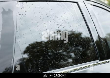 Gocce d'acqua sul vetro del finestrino dell'auto, primo piano Foto Stock