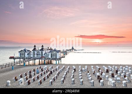 Sedie da spiaggia con cappuccio sulla spiaggia alla luce del mattino, molo di Sellin, isola di Ruegen, Mar Baltico, Meclemburgo-Vorpommern, Germania Foto Stock