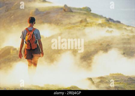 Persona che cammina attraverso il vapore di zolfo, Caldera, Gran Cratere, Vulcano, Isole Eolie, Italia Foto Stock