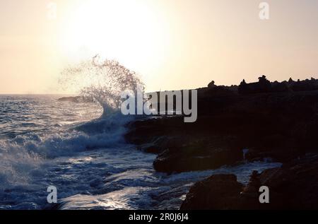 Onde che si schiantano sulla costa rocciosa al tramonto, vicino a Santanyi, Maiorca, Isole Baleari, Spagna, Europa Foto Stock