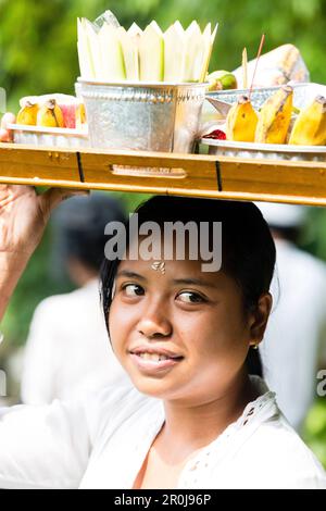 Giovane donna che porta il vassoio con offerte sul suo capo, Odalan Festival tempio, Munduk, Bali, Indonesia Foto Stock