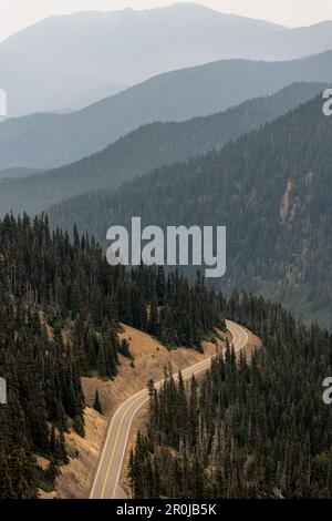 Strada che conduce fino alla cima del Parco Nazionale Olimpico di Hurricane Ridge con montagne a strati sullo sfondo. Foto Stock