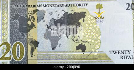 Grande frammento di lato inverso di 20 SAR Twenty Saudi Arabia Riyals banconote moneta conto emissione commemorativa con una mappa del mondo raffigurante Foto Stock