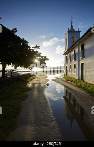 Sole mattutino sotto la pioggia piena Rua de Chapala, curch Iglesia de nostra Senora das Dores, centro storico, Paraty, Costa Verde, Rio de Janeiro, Brazi Foto Stock