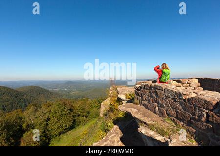 Giovane donna che fotografa il castello di Wegelnburg, vicino a Nothweiler, Dahner FelsenlandPalatinate Forest parco naturale, Renania-Palatinato, Germania Foto Stock
