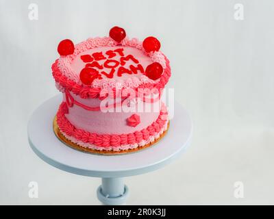 torta rossa rosa smerigliata per la festa delle madri con testo divertente che colma il meglio evah mamma su sfondo bianco studio Foto Stock