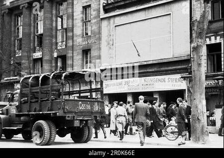 Militärlastkraftwagen und Passanten vor einem Theater, in dem die Revue 'Klingende Sterne' aufgeführt wird, im Berlin der Nachkriegszeit, Deutschland 1947. Foto Stock