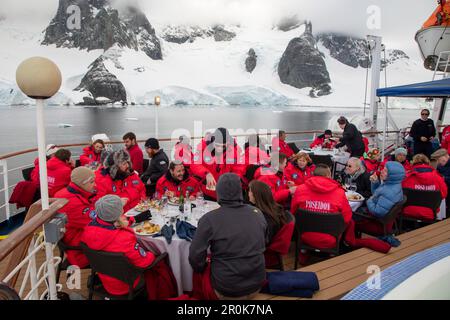 Cena barbecue sul ponte per i passeggeri della nave da crociera della spedizione MV Sea Spirit (spedizione Poseidon) vicino al canale Lemaire, Graham Land, Peninsul Antartico Foto Stock