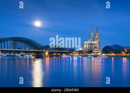 Luna piena, vista sul fiume Reno al ponte di Hohenzollern, Cattedrale di Colonia e il Musical Dome di Colonia, nella Renania settentrionale-Vestfalia, Germania Foto Stock