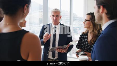 Condividere parte della sua saggezza commerciale. un uomo d'affari che ha un incontro con i suoi colleghi. Foto Stock
