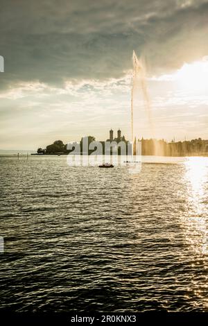 Fontana e nuvole al tramonto, Schlosskirche sullo sfondo, Friedrichshafen, Lago di Costanza, Baden-Württemberg, Germania Foto Stock