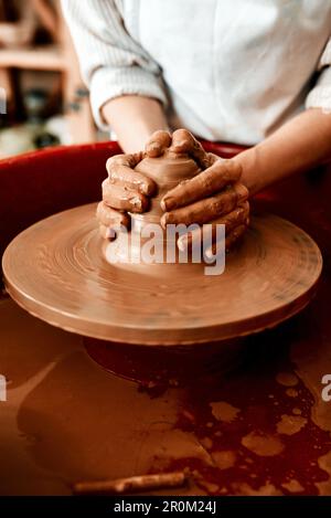 Questa è la migliore terapia kinda. una donna irriconoscibile che modella l'argilla su una ruota di ceramica. Foto Stock