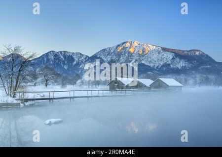 Boathouses sul Kochelsee di fronte al Jochberg, Schlehdorf, Tölzer Land, alta Baviera, Baviera, Germania Foto Stock