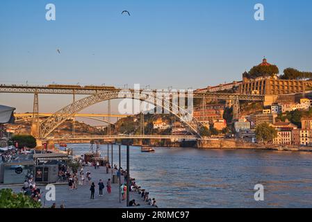 Cais da Ribeira sul Douro con vista sul Ponte Dom Luis i attraverso il Douro a Vila Nova de Gaia, Porto, Portogallo Foto Stock