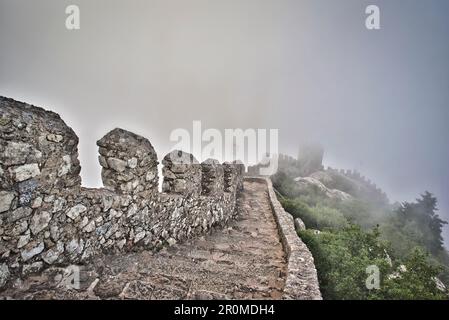 Ripide scale, muro e torre fortificata nella nebbia a Castelo dos Mouros Sintra, Lisbona, Portogallo Foto Stock