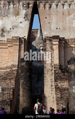 Turisti al Buddha seduto nel Parco storico di Sukhothai nel tempio Wat si Chum, antica città reale, Sukhothai, Thailandia Foto Stock