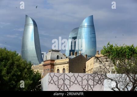 Vista dalla città vecchia con case rinnovate alle Torri Flame con la sua facciata in vetro blu, Baku, Mar Caspio, Azerbaigian, Asia Foto Stock