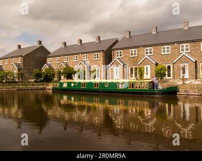 il battello verde ormeggiato sul lato del canale di Monmouthshire e Brecon vicino al bacino di Brecon Canal Wharf inizia/finisce il Canal Powys Mid Wales UK Foto Stock