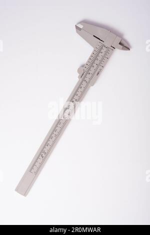 Calibro a corsoio in metallo, calibro a corsoio è uno strumento di misurazione utilizzato per misurare con precisione le dimensioni lineari su sfondo bianco Foto Stock