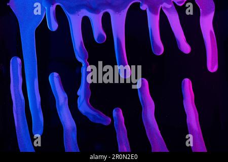 Fuoriuscite di pigmento al neon brillante che galleggiano su sfondo nero Foto Stock