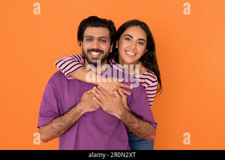 Ritratto di dolci giovani amanti indiani che abbraccia l'arancio Foto Stock