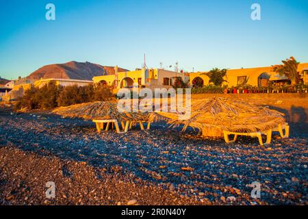 Le ville di ciottoli neri e sulla spiaggia di Avis Beach. Si trova vicino all'estremità meridionale dell'aeroporto internazionale di Santorini. Kamari Grecia,2013 Foto Stock