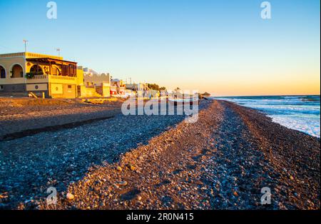 Le ville di ciottoli neri e sulla spiaggia di Avis Beach. Si trova vicino all'estremità meridionale dell'aeroporto internazionale di Santorini. Kamari Grecia,2013 Foto Stock