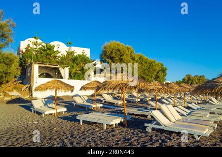 Le ville in ciottoli neri e sulla spiaggia di Avis Beach. Si trova vicino all'estremità meridionale dell'aeroporto internazionale di Santorini, Kamari, Grecia Foto Stock