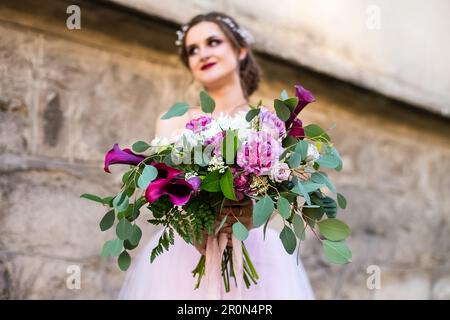 Bouquet di nozze in mani di sposa, primo piano, vivido rosso Calla gigli fiori Foto Stock