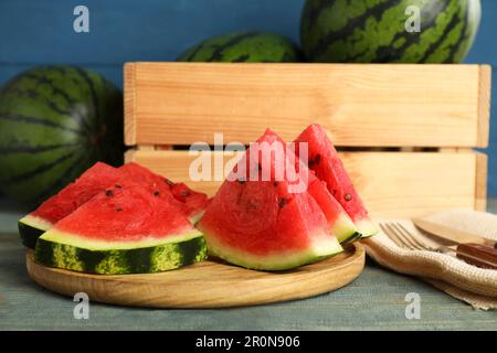 Fette di delizioso cocomero maturo su un tavolo di legno azzurro Foto Stock