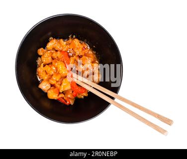 porzione di pollo vietnamita in salsa agrodolce con verdure in ciotola con crocchette tagliate su fondo bianco Foto Stock