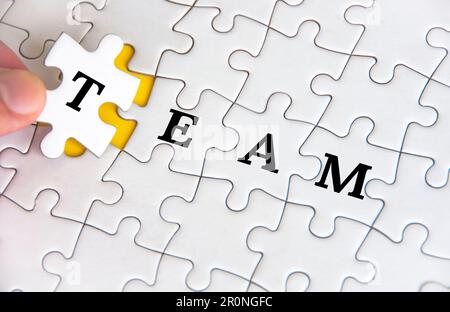 Testo di squadra su puzzle bianco. Concetto aziendale e di lavoro di squadra. Foto Stock