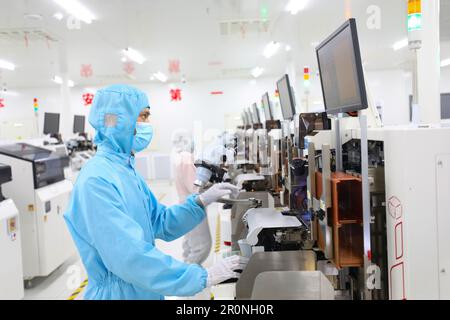 CHONGQING, CINA - 9 MAGGIO 2023 - i lavoratori osservano la produzione di chip elettronici attraverso un display elettronico presso il laboratorio di produzione del Radi Foto Stock