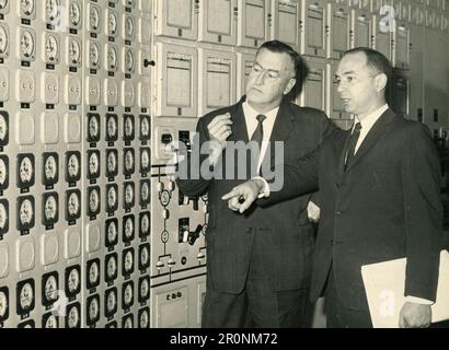 Ispettore generale dell'Agenzia internazionale dell'energia atomica Allan McKnight e membro del team Frank Arsenault nella sala di controllo della centrale nucleare di Bradwell, Regno Unito 1966 Foto Stock