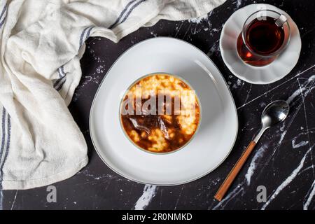 Budino di riso su sfondo scuro. Dessert al budino di riso preparato con latte. Specialità della cucina turca. Nome locale sütlaç. Vista dall'alto Foto Stock