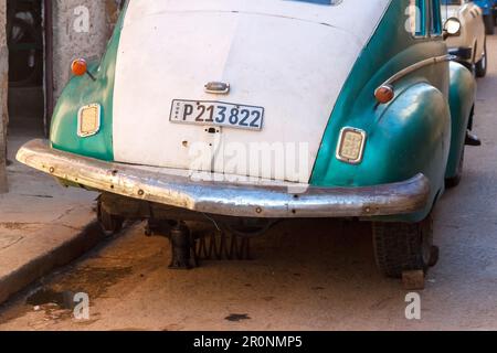 Havana, Cuba - 26 aprile 2023: Una vecchia macchina americana manca una ruota. È parcheggiato in strada. Questi tipi di veicoli sono utilizzati come taxi privati f Foto Stock