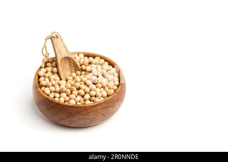 Semi di soia in una ciotola di legno con un cucchiaio di legno su fondo bianco con spazio per le copie Foto Stock